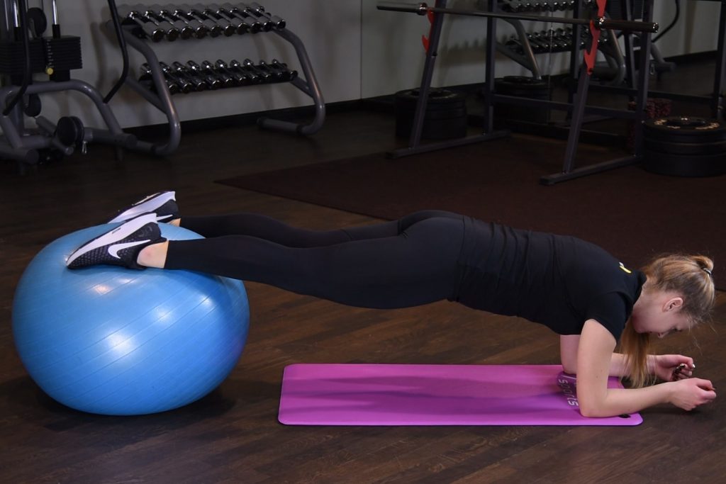 Deska na przedramionach ze stopami na piłce do ćwiczeń