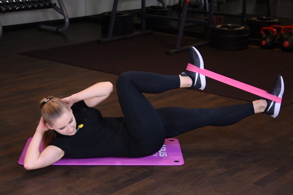 Rowerek w leżeniu na plecach z rotacją tułowia oraz gumą mini band