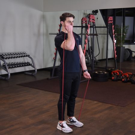 Naprzemienne uginanie ramion z gumą power band w staniu