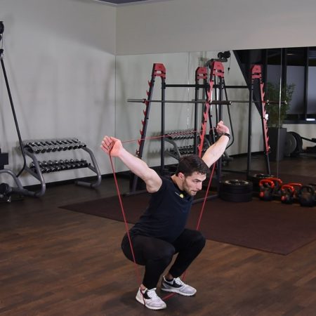 Przysiad OHS z gumą power band nad głową