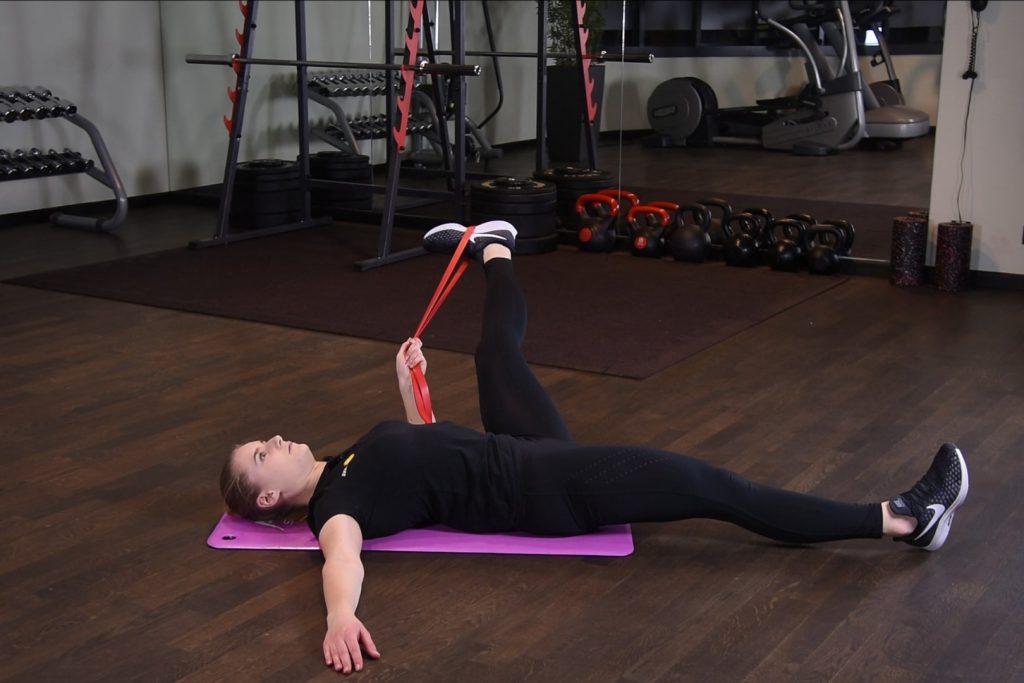 Rozciąganie przywodzicieli uda z gumą power band w leżeniu tyłem