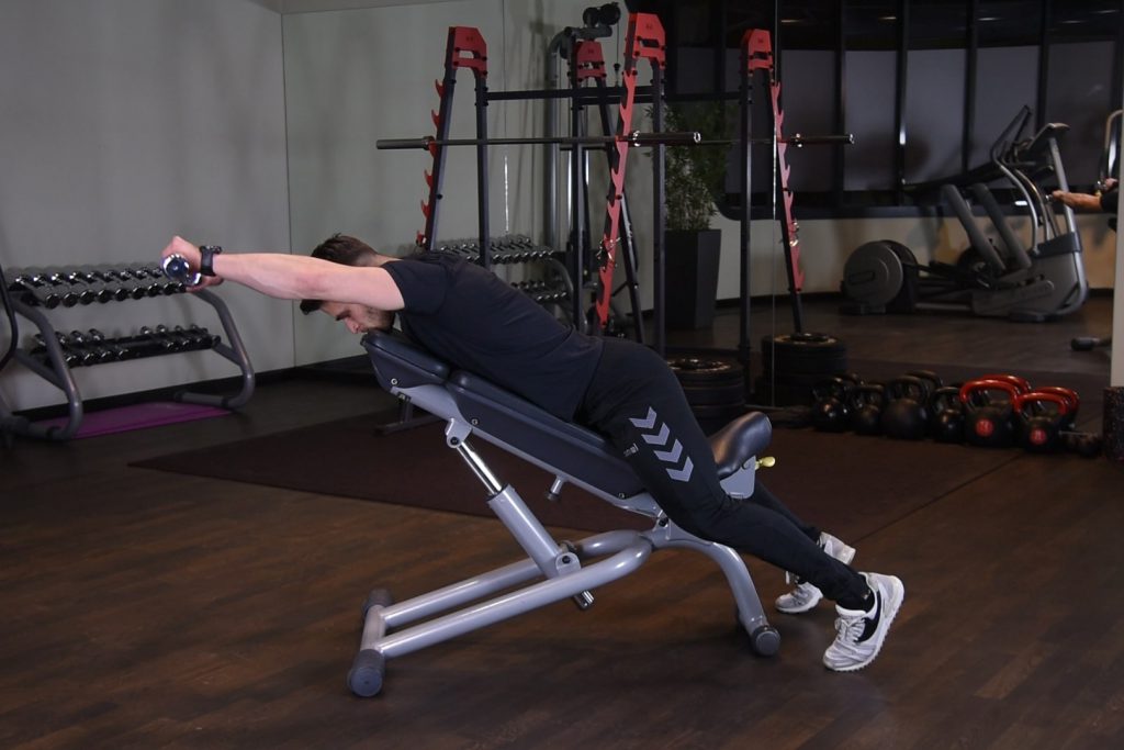 Unoszenie hantli w przód leżąc przodem na ławce dodatniej