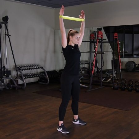 Przysiad z gumą mini band z rękami nad głowę OHS - just be fit